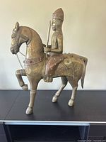 Full view of brass and wood Indian horse and rider statue on tabletop