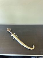 Full view of dagger sheathed, showing handle, scabbard curvature and engravings