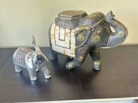 Both elephant figurines side by side showing relative sizes and materials