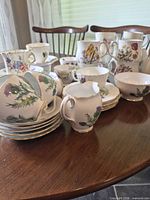 Group view of teapot, teacups, saucers and plates on table