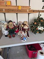 Group of multiple Santa figurines and wreath on table