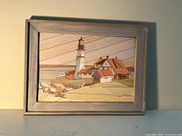 Full framed wooden intarsia artwork showing lighthouse coastal scene