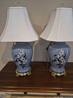Pair of blue floral ceramic table lamps with shades on table