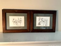 Both framed prints side by side on shelf