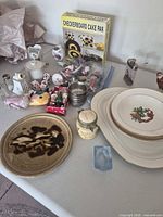 Stack of four dinner plates with gold rims beside additional household items