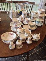 Full lot overview on tabletop showing quantity and variety of porcelain items