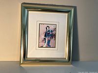 Front view of framed print showing artwork, mat and gold frame