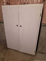 Front view of closed white cabinet showing two doors