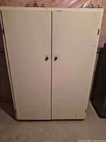 Front view of closed white double-door cabinet
