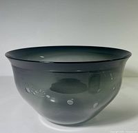 Side view of smoke-grey art glass bowl showing flared rim and bubble inclusions
