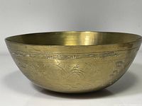 Side view of brass bowl showing etched Chinese motifs and overall condition