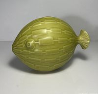 Side view of green ceramic fish sculpture