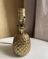 Full view of pineapple lamp showing brass-tone finish and socket