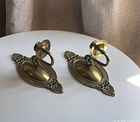 Pair of brass wall sconces on table showing overall form