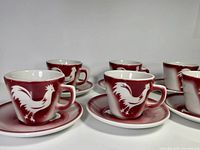 Front view showing cups on saucers with rooster design