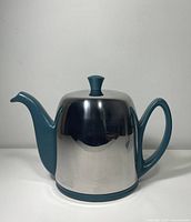 Right-side view of teal teapot with stainless steel cover