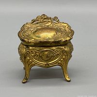 front view of gilded brass floral trinket box with lid closed