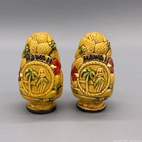 front view of both ceramic shakers showing Hawaii medallion and hibiscus accents