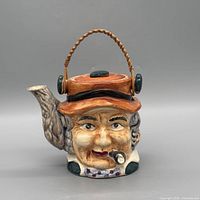 Front view showing character face, spout, and handle