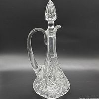Full view of clear crystal cut glass decanter with stopper, handle and spout