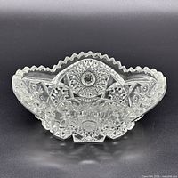 Front view of clear pressed glass bowl showing starburst pattern and scalloped rim