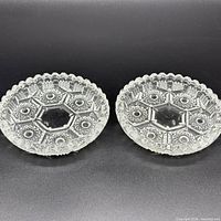 Pair of clear pressed glass saucers front view