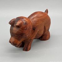 Side view of carved wood pig showing overall form and grain
