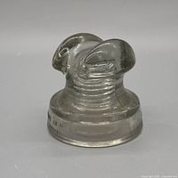 Front view of clear light smoky glass insulator showing form and color