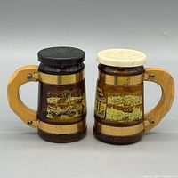Front view of both shakers showing graphics, lids, wood handles