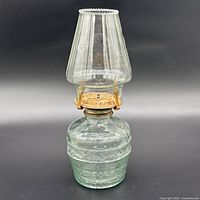 Full view of lamp showing chimney, burner and pressed glass base