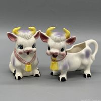 Front view of both cow creamers showing colors and bells