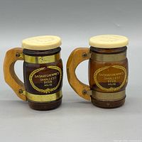 Front view of both miniature souvenir mugs showing labels and construction