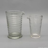 Front view of both glass measuring jugs showing embossed rings and spouts