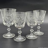 Front view of four crystal wine glasses showing full pattern