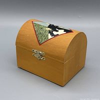 Front angled view of wooden domed jewelry box showing cow motif and latch
