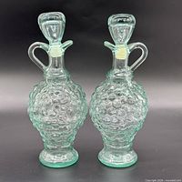 Front view of both Vetreria Etrusca aqua hobnail cruets with stoppers