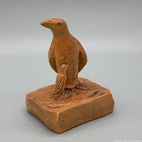 Front left view of whole wood penguin carving on block base