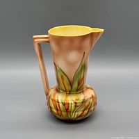 Front view of ceramic pitcher showing floral decoration and handle