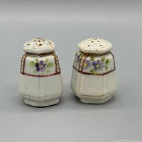 Front view of both shakers showing floral panels and perforated tops