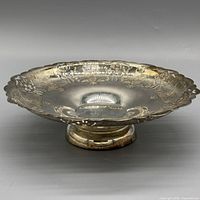 Side view of silverplate footed compote bowl showing pedestal base and ornate rim