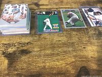 Stack of baseball cards in toploaders and three featured cards laid out