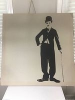 Full view of square canvas showing entire Charlie Chaplin silhouette and hanging cord