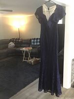 Front view of navy lace evening gown hanging