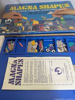 Box lid and open game showing tray compartments and instruction sheet