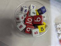 Tub of assorted red, yellow and white numbered dice