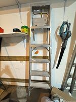 Full view of aluminum 6-step ladder leaning against wall