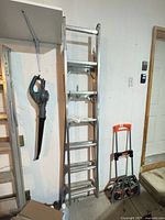 Full view of aluminum extension ladder leaned against wall