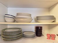 Cabinet view with stacked plates, bowls, ramekins and egg cups