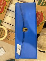 Closed blue case showing gold clasp