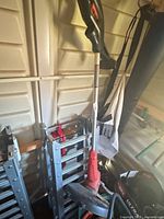 Full view of string trimmer leaning against wall